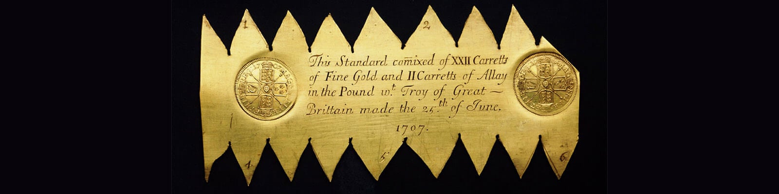 A sheet of gold (a trial plate) with triangles cut from the side making it look like saw teeth