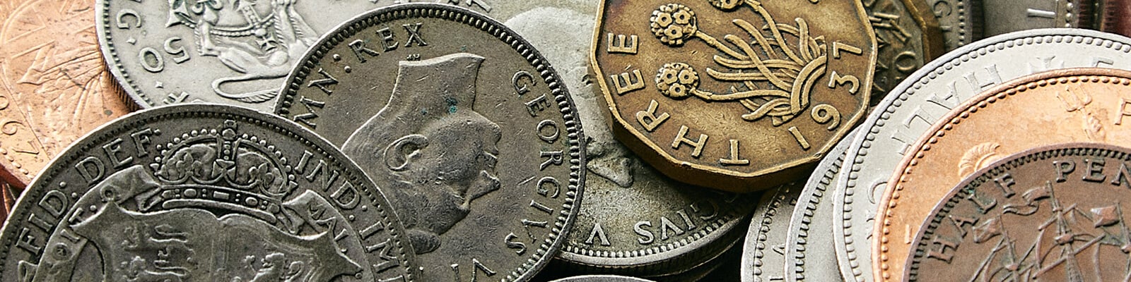 A close up picture of a variety of British pre-decimal coins