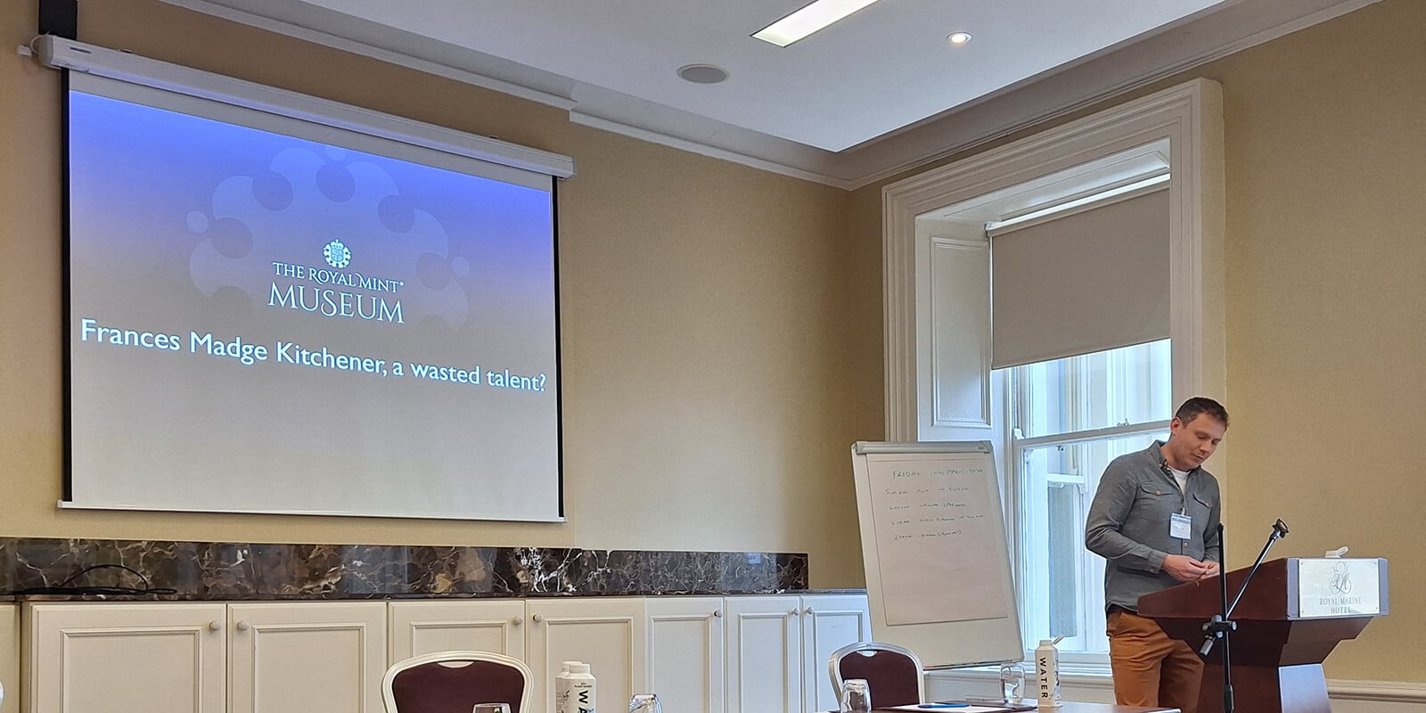 Chris Barker standing behind a lectern giving a talk at the British Association of Numismatic Societies Congress