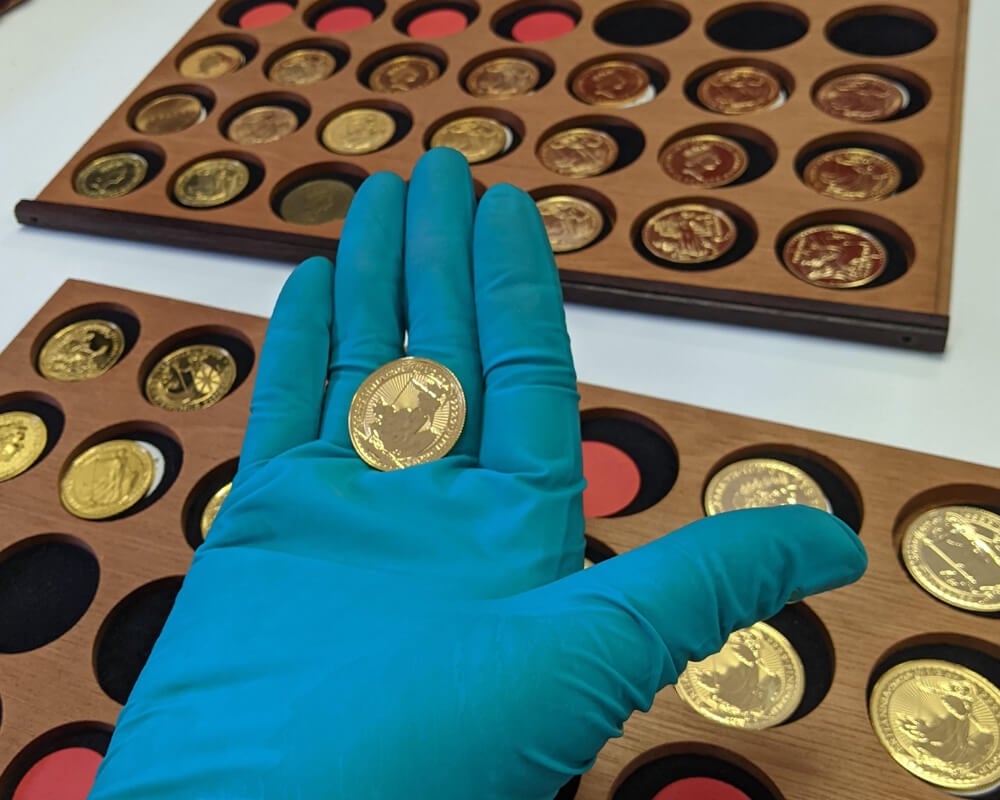 Sarah Tyley putting gold Britannia coins into a coin tray.jpg