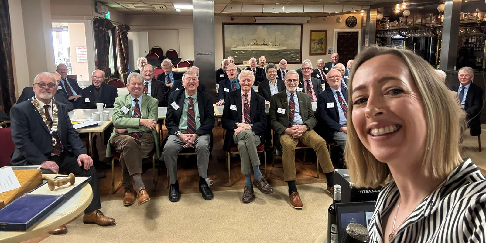 Abigail Kenvyn from the Royal Mint Museum takes a selfie with her seated audience of Penarth Probus club smiling in the background