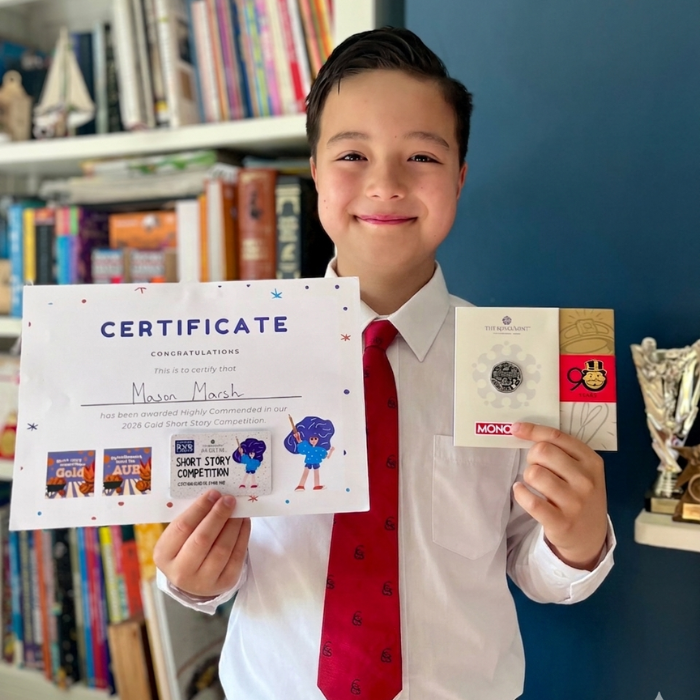 Mason holding the certificate and prize