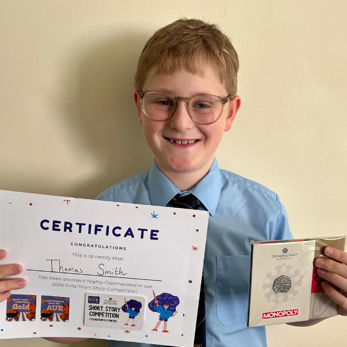 Thomas holding a certificate and prize
