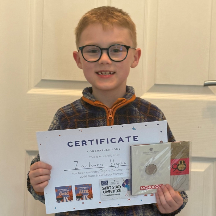Zachary holding the certificate and prize