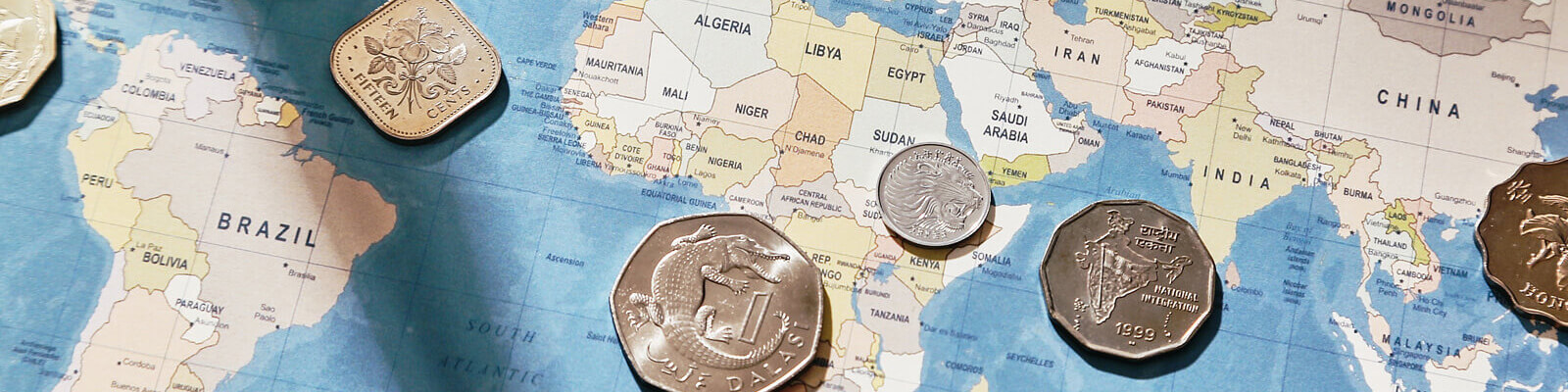 A map of the world with overseas coins laid on top