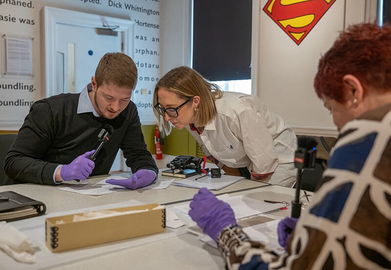 A group of circuit boards next to jewellery made from gold recycled from circuit boards