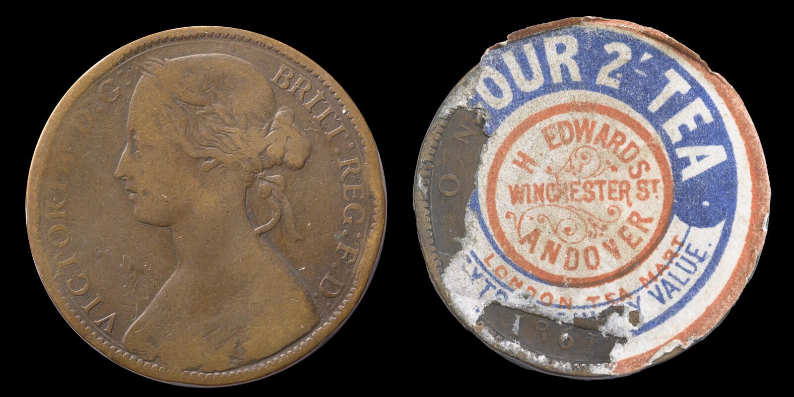 An 1861 bronze penny with a sticker on advertising a shop in Andover