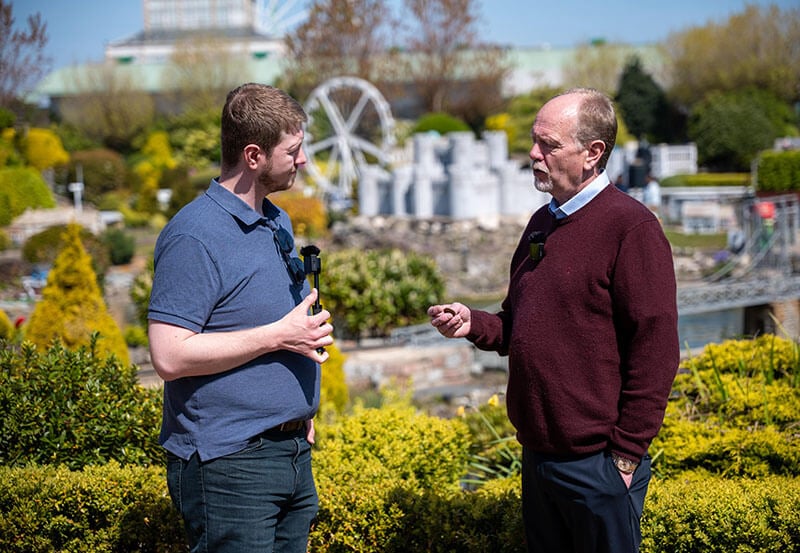 David Mason interviewing Peter Williamson on a sunny day in the gardens outside Williamson's Old Penny Arcade in Great Yarmouth