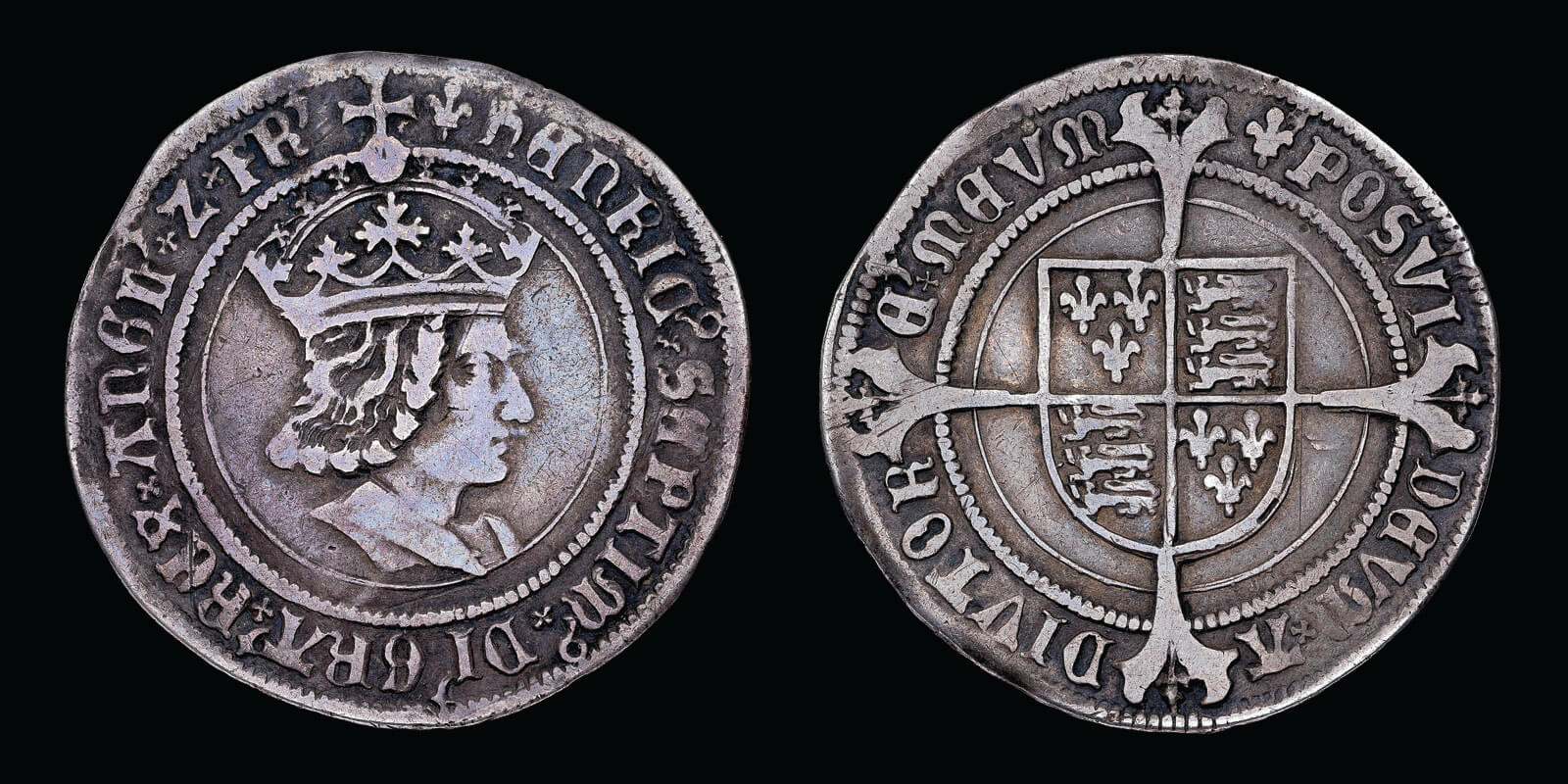 A silver coin with a realistic portrait of King Henry VII on the obverse and a shield and cross on the reverse