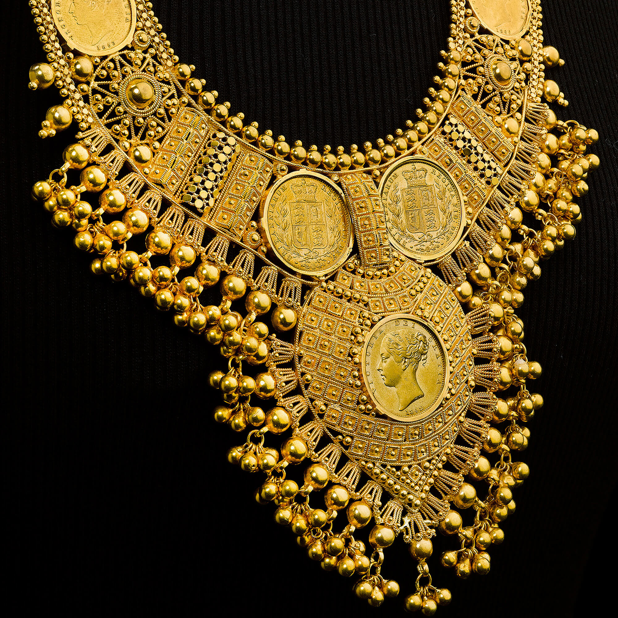 An elaborate necklace featuring a number of gold coins set into intricate gold fixings