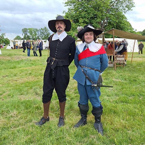 Two members of the Sealed Knot Society in Civil War costume as a Parliamentarian preacher and Royalist Officer.