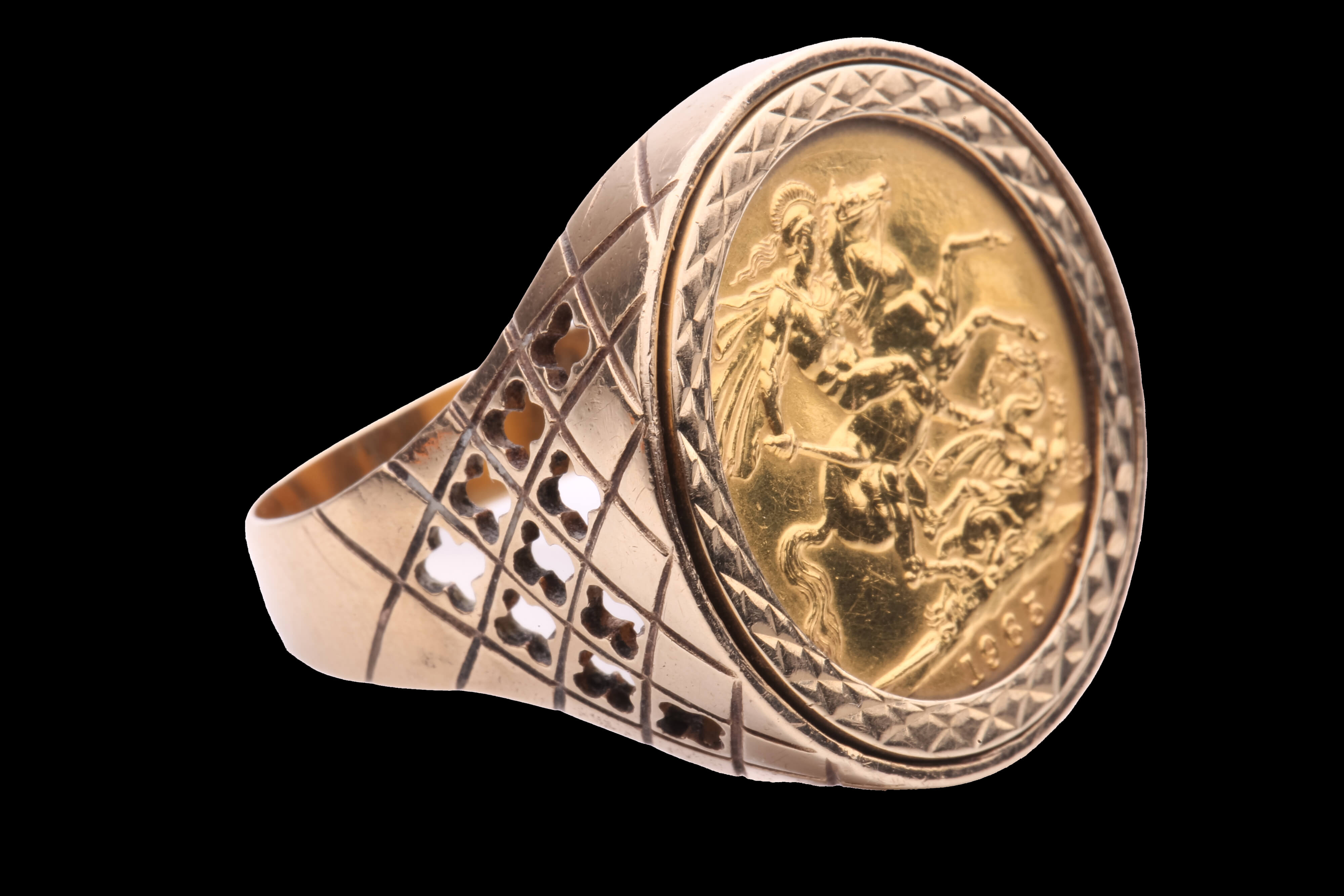 A gold ring with a large gold sovereign coin mounted on it against a black background. Licenced from Shutterstock