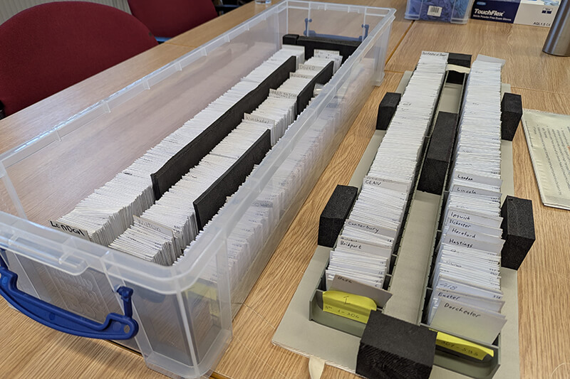 A large clear plastic boxes filled with rows of white envelopes each containing a single coin from the Chew Valley Hoard
